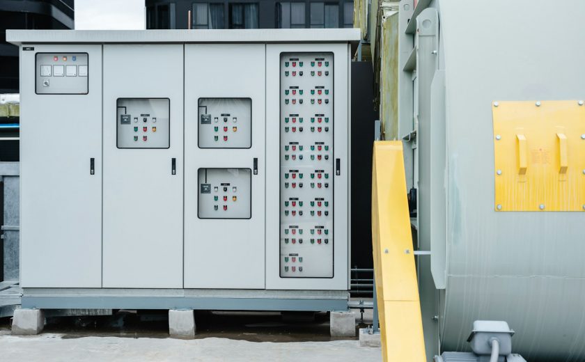 The electrical room of a commercial building contains multiple smart meters, a main power breaker.