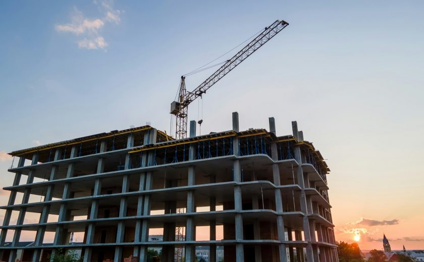 Tower lifting crane and high residential apartment building with monolithic frame under construction